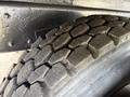 Close-up of a heavy-duty tire with a deep tread pattern designed for traction and durability on the 1998 Freightliner FL80