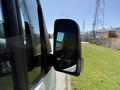 Side mirror of a 2023 Mercedes-Benz Sprinter showing a clear reflection of the surrounding environment