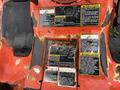 A close-up view of the dashboard controls of a 2012 Kubota F3680 with several warning and caution labels displayed on a worn surface