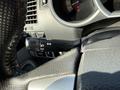 Close-up view of the steering wheel of a 2015 Toyota Tacoma showing the turn signal and headlights control stalk. The textured grip is visible along with various dashboard controls