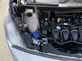 A 2021 Ford Transit Connect with the hood open exposing the engine compartment showing various components including the coolant reservoir and engine parts