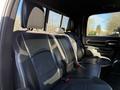 A 2023 RAM 3500 interior featuring a spacious back seat with black leather upholstery and a center armrest