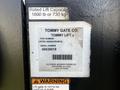 A label on a lift gate featuring the brand name Tommy Gate Co with part number VST92-1650541EA0618 and a series of numbers indicating the serial number and manufacturer location