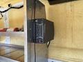 A 2016 Ford Transit van interior with a black inverter mounted on a metal shelf