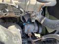 A close-up view of a 2022 Freightliner Cascadia engine component featuring various pipes and a turbocharger with blue connectors