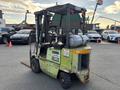 A weathered 2000 Clark GPS 15 forklift with a tank mounted on the side and a fork attachment in front