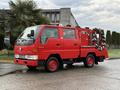 A red 2001 Toyota Dyna fire truck equipped with hoses and firefighting equipment on the back