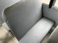 A gray upholstered bus seat with a smooth surface and slight texture designed for passenger comfort