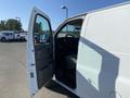 A 2012 GMC Savana van with an open front door revealing the driver's seat and dashboard