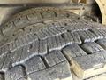 Close-up of a large, rugged tire from a 1994 Volvo FE 42 displaying deep treads and a worn surface indicating heavy use