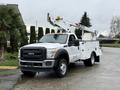 A white 2012 Ford F-450 SD with a bucket lift attachment and utility box mounted in the bed
