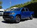 A blue 2021 Chevrolet Colorado pickup truck with a black grille and silver running boards parked in a well-lit area