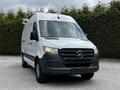 A 2020 Mercedes-Benz Sprinter van with a white body and black front grille parked on a gravel surface