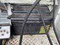 A 2008 Ford Econoline vehicle battery with a black casing and yellow labels alongside attached cables