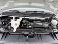 The engine compartment of a 2014 GMC Savana featuring the engine, coolant reservoir, and various components with visible electrical and fluid connections