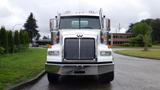 A white 2019 Western Star Trucks 4900 with a prominent grille and chrome accents is positioned facing the viewer with its headlights visible