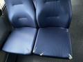 A pair of blue seats from a 2017 Chevrolet Express with visible wear and tear showing frayed edges on one of the seat cushions