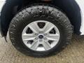 Close-up of a silver wheel rim with five spokes showcasing a rugged black tire mounted on a 2017 Ford F-150