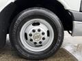 A close-up of a silver wheel on a 2013 Chevrolet Express featuring a Chevrolet logo and a black tire with Rivera GT10 markings