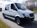 A white 2016 Mercedes-Benz Sprinter van with a black front grille and alloy wheels parked on a gravel surface