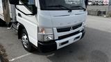 A white 2018 Mitsubishi Fuso FE truck with a prominent front grille and headlights parked on a lot