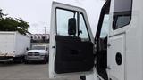 A white 2012 International 7400 truck with its driver's door open showcasing the interior details of the cab