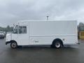 A white 2012 Ford Econoline delivery van with a rectangular cargo area and missing branding on the side