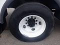 Close-up of a wheel of a 2011 Ford F-750 featuring a black hub and white rim with six bolt holes and a large tire with visible tread pattern