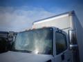 A 2013 Hino 24 foot truck with a white cab and silver cargo box showing condensation on the windshield