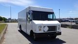 A white 2011 Ford Econoline delivery van with a large cargo space and a blank license plate area positioned in the foreground