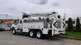 A 2012 International 7400 truck equipped with a hydraulic boom and utility bed designed for maintenance and repair work.