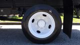 Close-up of a white wheel on a 2006 Ford F-650 showcasing a six-bolt pattern and black tire tread