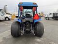 A blue 2007 New Holland TN70A tractor viewed from the rear with large tires and a red warning triangle attached