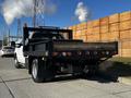 A 2011 Ford F-350 SD truck with a flatbed and a black rear frame featuring multiple lights and a mesh safety guard