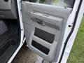 The image shows the driver-side door of a 2013 Ford E-350 with a gray interior panel and a handle for opening the door