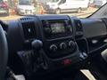 Interior of a 2016 RAM Promaster featuring a central dashboard display radio controls and gear shift along with climate control knobs