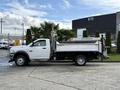 A white 2012 Dodge Ram 5500 with a dump bed and side-mounted toolboxes parked on a lot