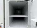 Interior view of a 2020 International MV607 truck's storage compartment featuring two shelves and a smooth white surface