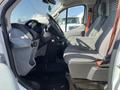 Interior view of a 2016 Ford Transit showing the driver's seat dashboard and steering wheel with gray fabric seating