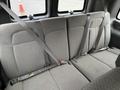 The back seat of a 2023 GMC Savana with gray fabric upholstery and three seat belts fastened