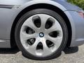 Close-up of a silver alloy wheel with a BMW logo featuring eight spokes and a black tire mounted on it