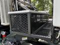 A metallic storage box with a diamond mesh design attached to the side of a truck showcasing the 2012 Autocar Xpert model