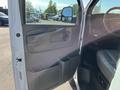 Interior view of the driver's side door of a 2014 Chevrolet Express featuring a handle storage compartment and controls for windows and locks