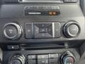 Close-up view of dashboard controls in a 2017 Ford F-250 SD featuring volume and tuning knobs along with other buttons for audio and airbag status