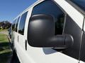 Close-up of the side mirror of a white 2021 Chevrolet Express van with a black casing