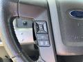 The steering wheel of a 2014 Ford F-150 featuring control buttons for settings including OK and cruise control options