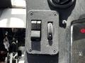 Close-up of a control panel with two switches and a rotary dial on a textured black surface