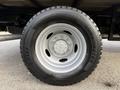 Close-up of a silver alloy wheel with a black tire of a 2020 Ford F-550 featuring the branding of Cooper Tires