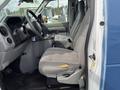 Interior of a 2009 Ford Econoline showing two gray seats with visible wear and a simple dashboard layout