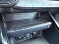 A close-up view of the center console in a 2024 Kia Forte5 featuring a wireless charging pad and USB ports